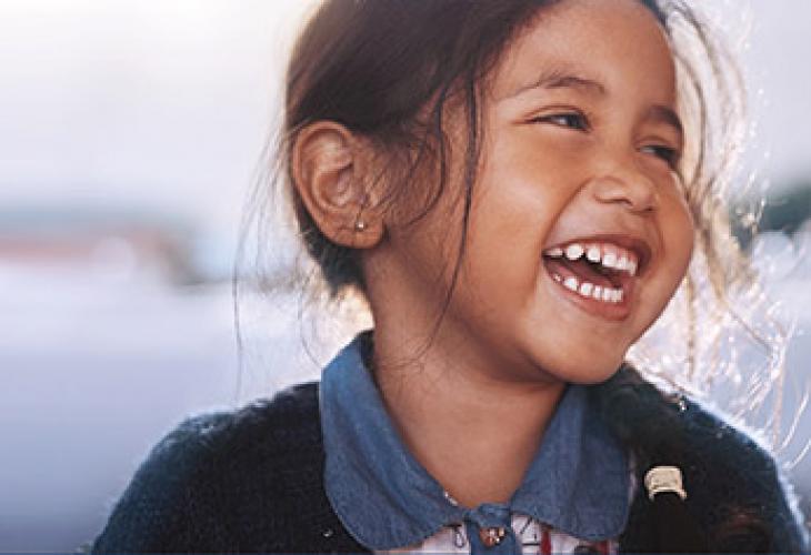 petite fille brune qui rit